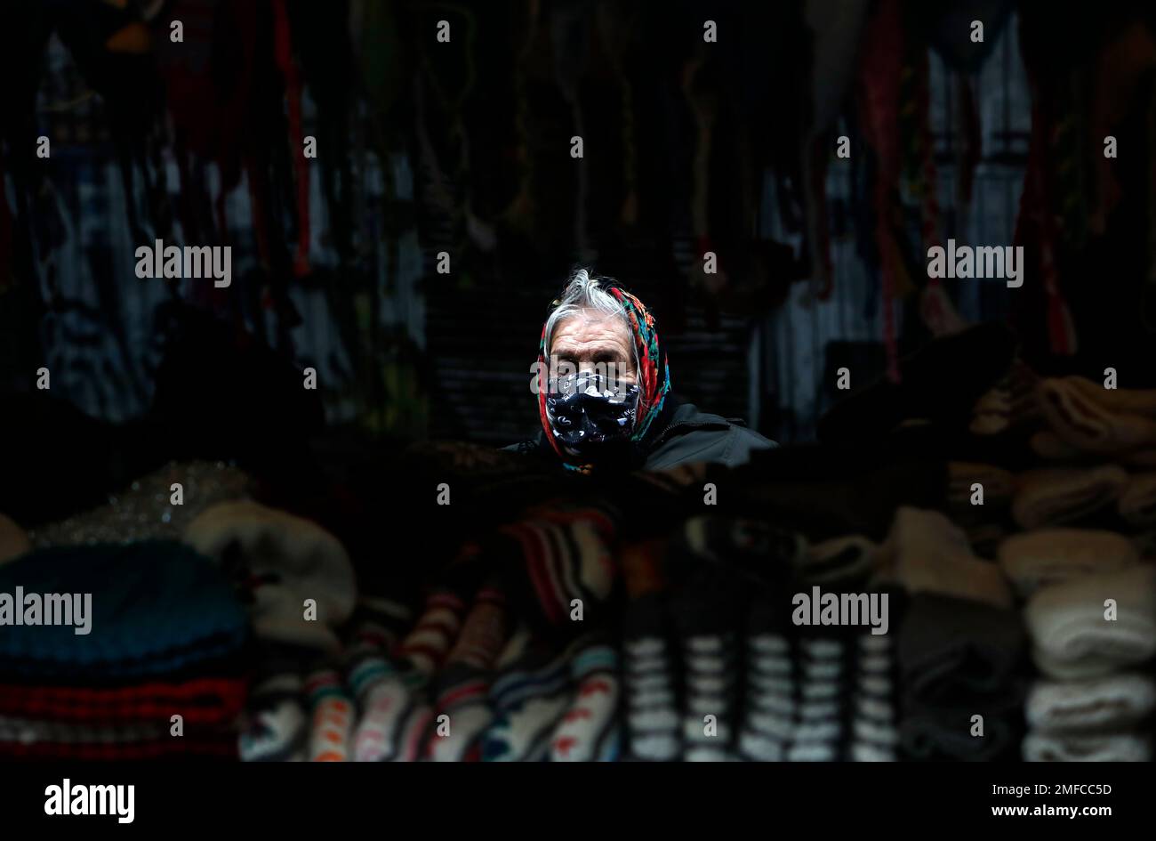 A street vendor wearing a face mask to protect against coronavirus waits in Belgrade's main pedestrian street, in Serbia, Thursday, Dec. 31, 2020. (AP Photo/Darko Vojinovic) Stockfoto