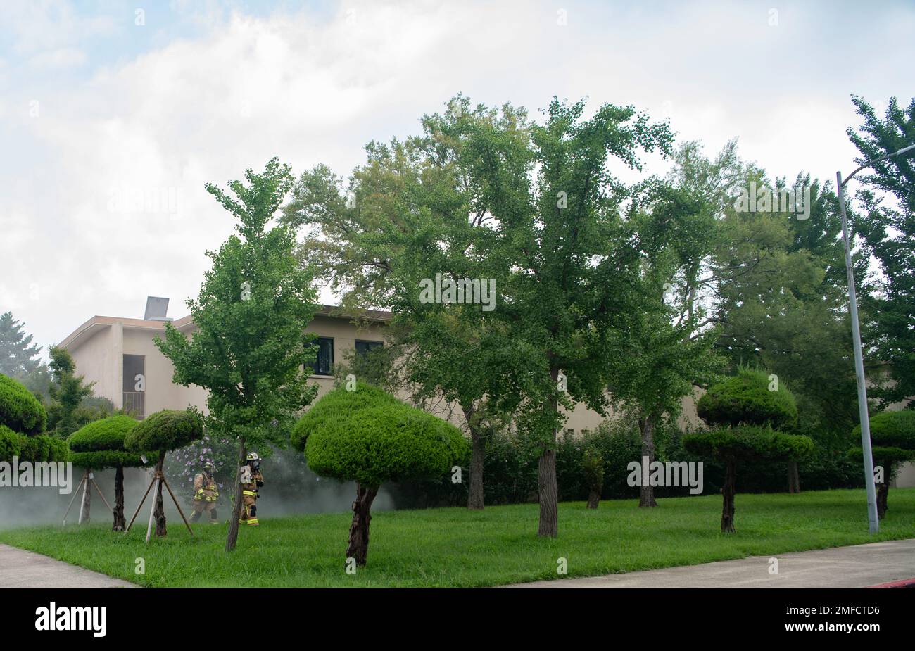 Airman 1. Class Micah Low, Left, 8. Civil Engineer Squadron Fire Services Flug Feuerwehrmann, und Staff Sgt. Bobby Arguelles, 8. CES Feuerwehr Flugbesatzungsleiter, verlässt ein Gebäude während einer Schulungsveranstaltung auf dem Luftwaffenstützpunkt Kunsan, Republik Korea, 19. August 2022. Während der Schulung übten die Feuerwehrleute das sichere Betreten des Gebäudes, die Rettung von Opfern und das Auffinden und Löschen der Flammen. Stockfoto