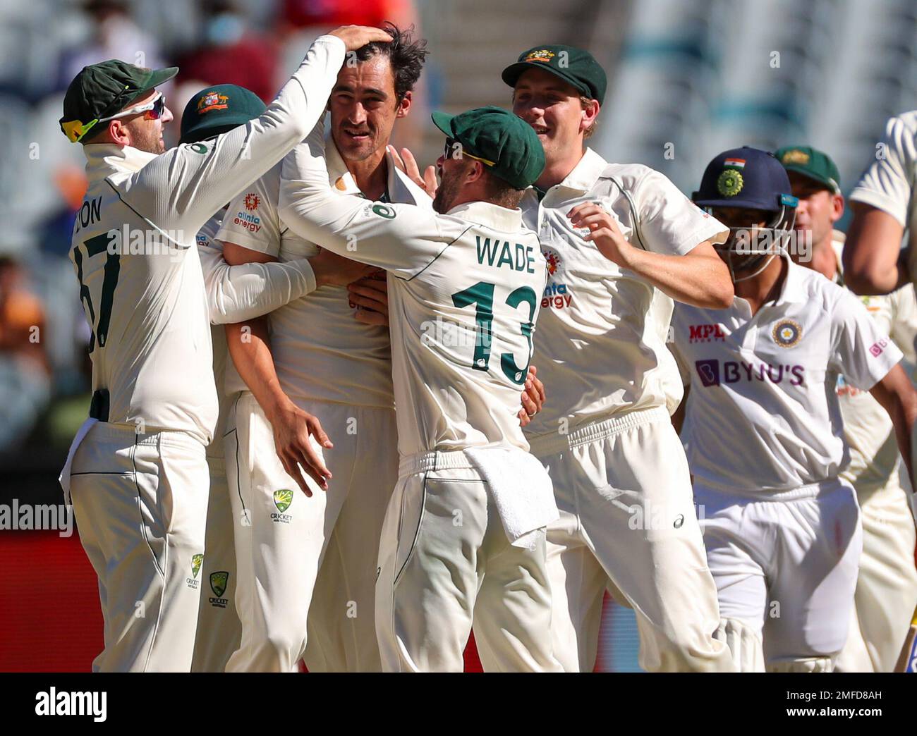 Australia's Mitchell Starc, centre, is congratulated by teammates after dismissing India's
