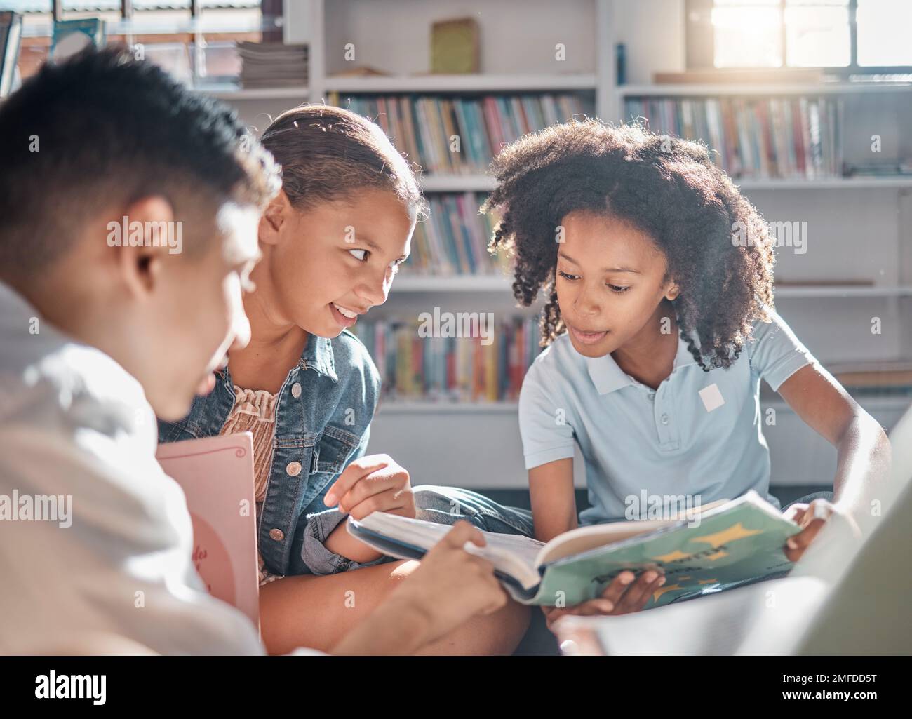 Bildung, Geschichtenerzählen oder Schüler, die in einer Bibliothek lesen, um sich in der Gruppe weiterzuentwickeln oder weiterzuentwickeln. Vielfalt, Kinder oder Kinder, die reden oder sprechen Stockfoto