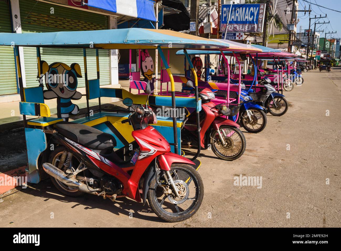 Typische Tuk Tuks von Koh Lanta. Motorradtaxis im Cartoon-Stil mit Beiwagen, die hintereinander geparkt sind. Ko Lanta, Krabi, Thailand. 30. November 2022. Stockfoto
