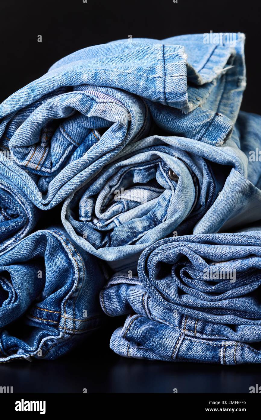 Viele verdrehte Jeans auf dunklem Hintergrund Stockfoto