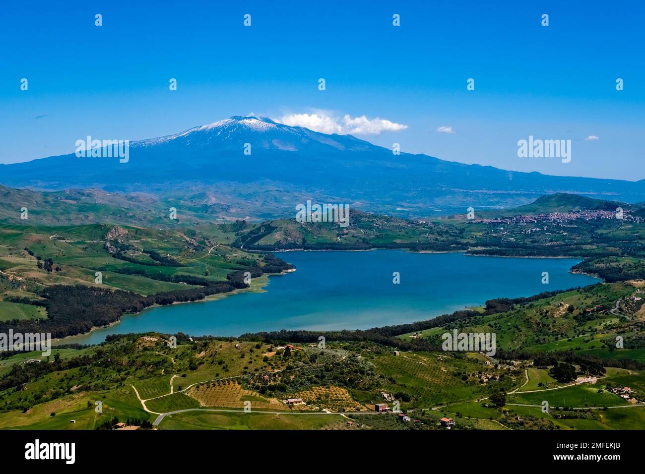 Luftaufnahme auf die landwirtschaftliche Landschaft mit grünen Hügeln, Bäumen und Feldern, Pozzillo See, Lago di Pozzillo und dem Vulkan Ätna, der Wolken von Smo emittiert Stockfoto