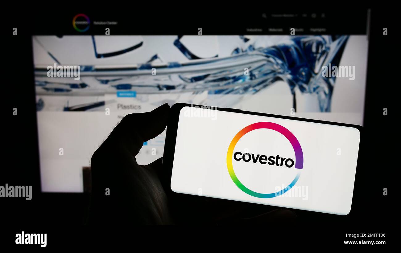 Person, die ein Smartphone mit dem Logo des deutschen Chemieunternehmens Covestro AG auf dem Bildschirm vor der Website hält. Konzentrieren Sie sich auf das Display des Telefons. Stockfoto