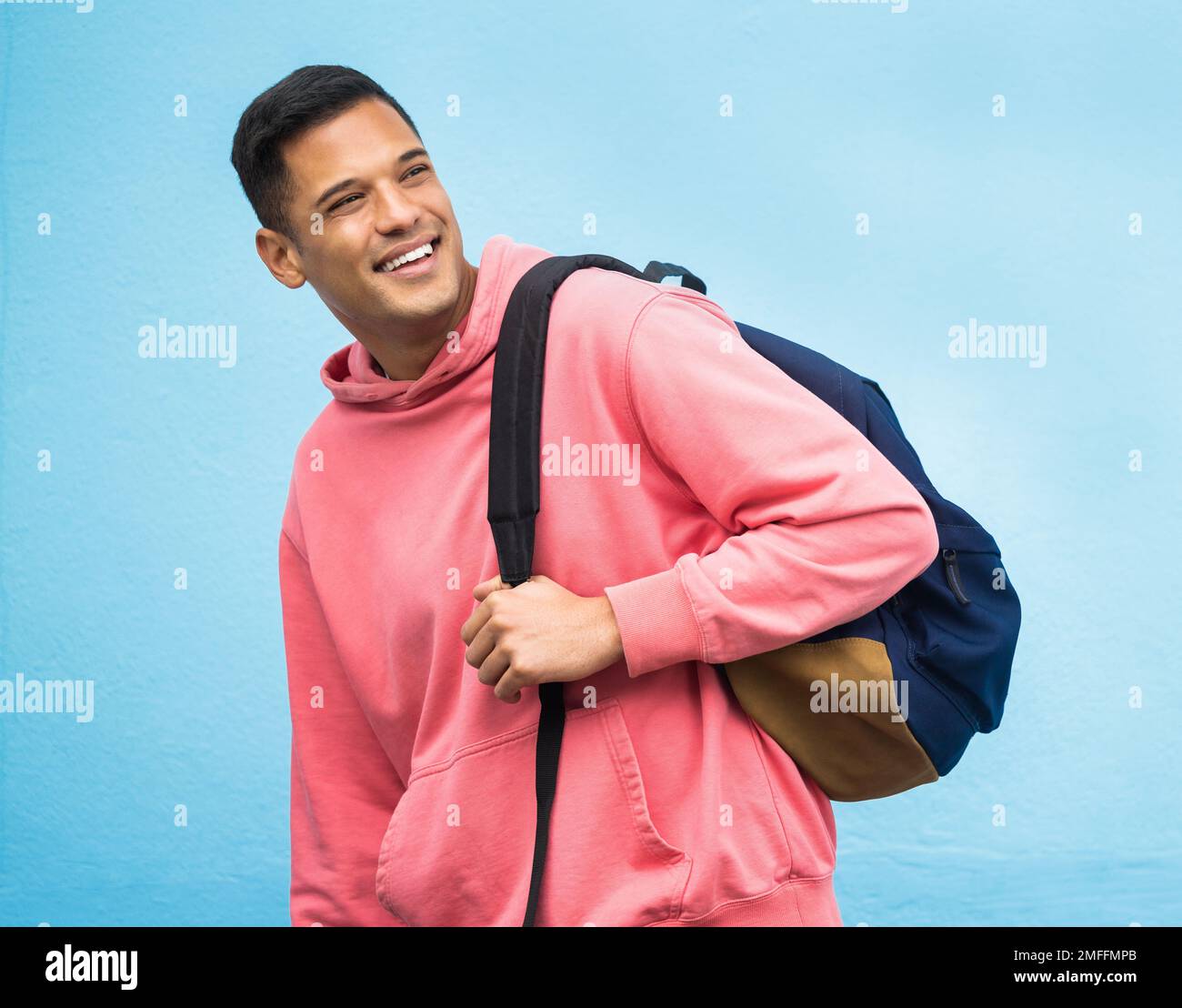 Ein Mann, ein Rucksack und ein Student, glücklich im Studio, lachend und lächelnd auf blauem Hintergrund. Junge, gutaussehende und College-Studentin, die sich auf Bildung freut Stockfoto