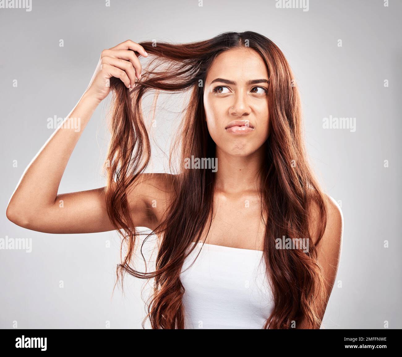 Frau, Haarpflege und wütendes Gesicht im Studio für Luxus Wellness, beschädigte Haarausfall oder frustriert. Aufgebrachtes Modell, Stress im Salon und unordentlicher Haarfehler Stockfoto