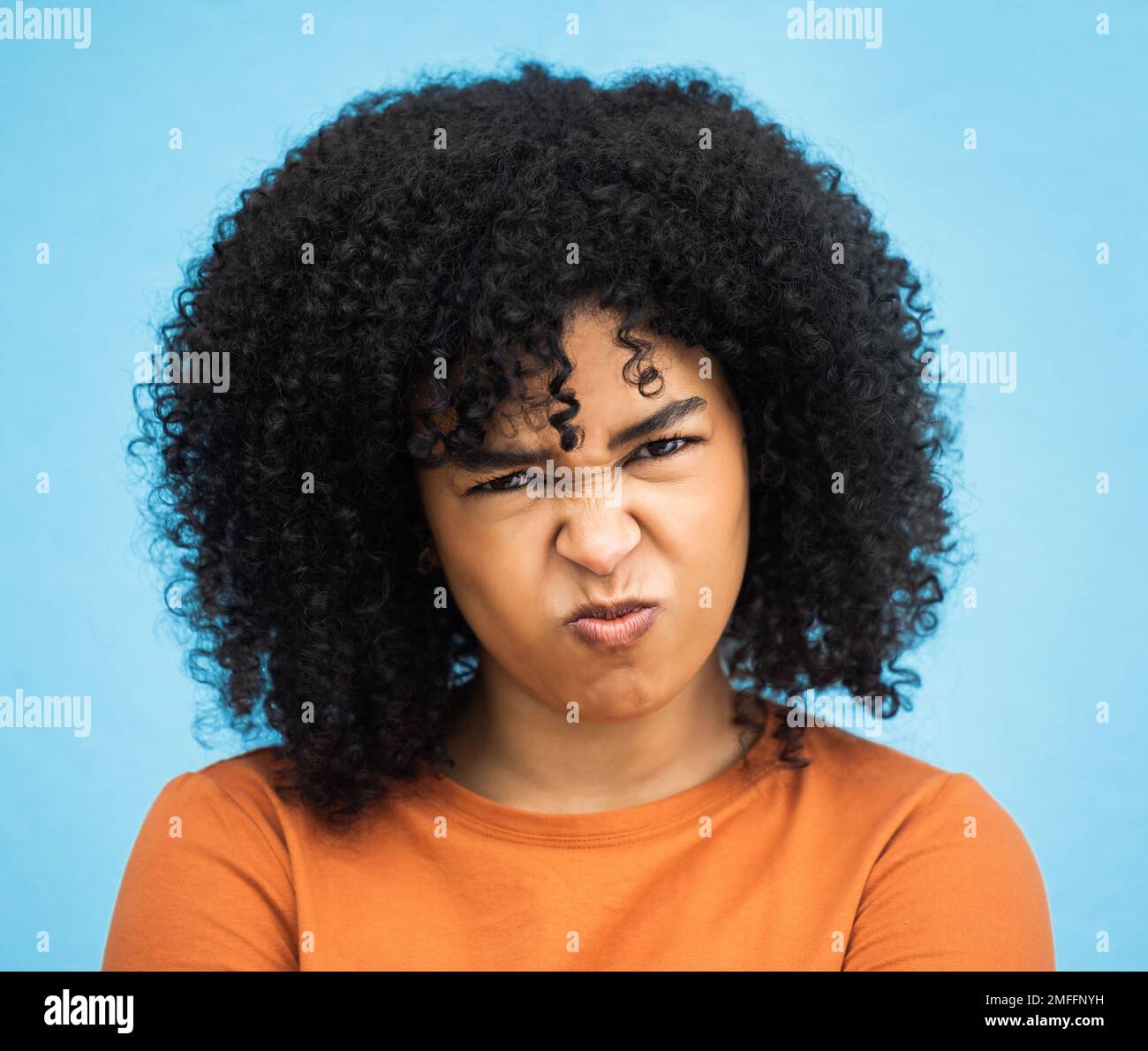 Schwarze Frau, Porträt oder wütender Gesichtsausdruck auf isoliertem blauem Hintergrund bei psychisch bedingtem Burnout. Kopfschuss, Model oder Person mit wütend, genervt oder Stockfoto
