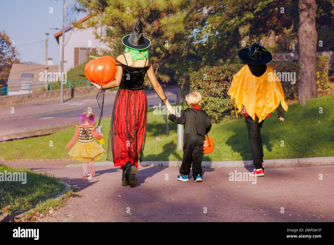 Rückansicht einer Mutter mit Kindern in Halloween-Kostümen Stockfoto