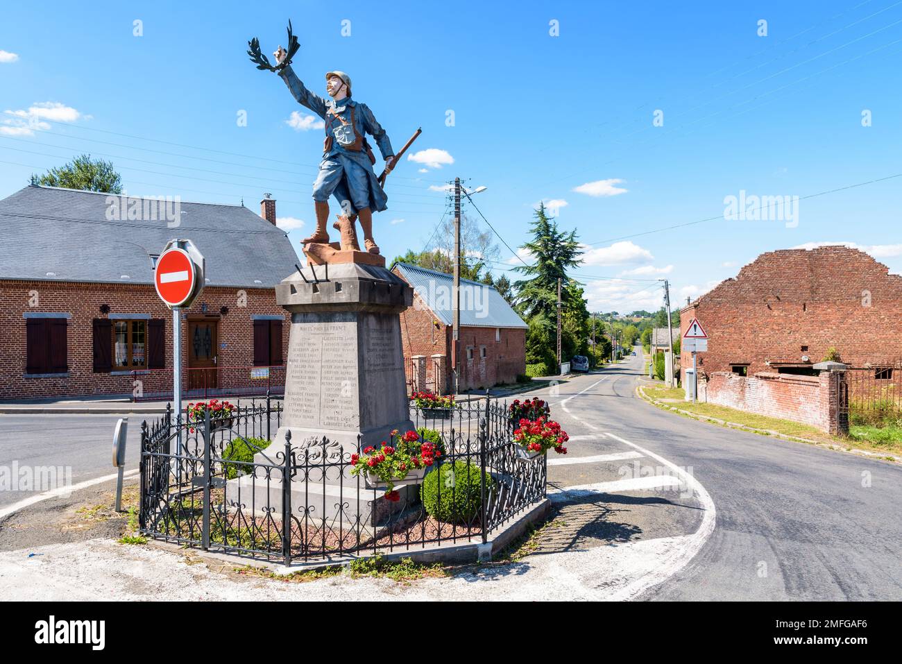 Das Kriegsdenkmal in Marly-Gomont, Frankreich, umfasst eine Statue eines französischen Soldaten des Ersten Weltkriegs, genannt „Poilu“, mit einem Gewehr und Lorbeeren. Stockfoto