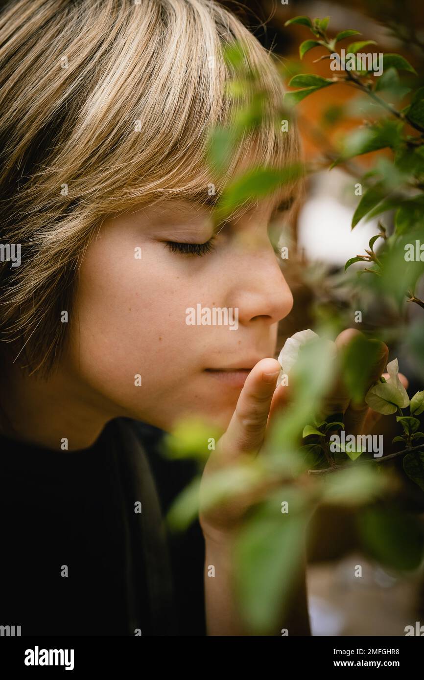 Ein Junge, der Blumen riecht Stockfoto
