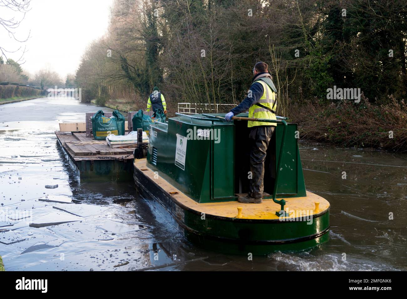 Ein Wartungsboot, das im Winter durch dickes Eis fährt, Grand Union Canal, Warwick, Großbritannien Stockfoto