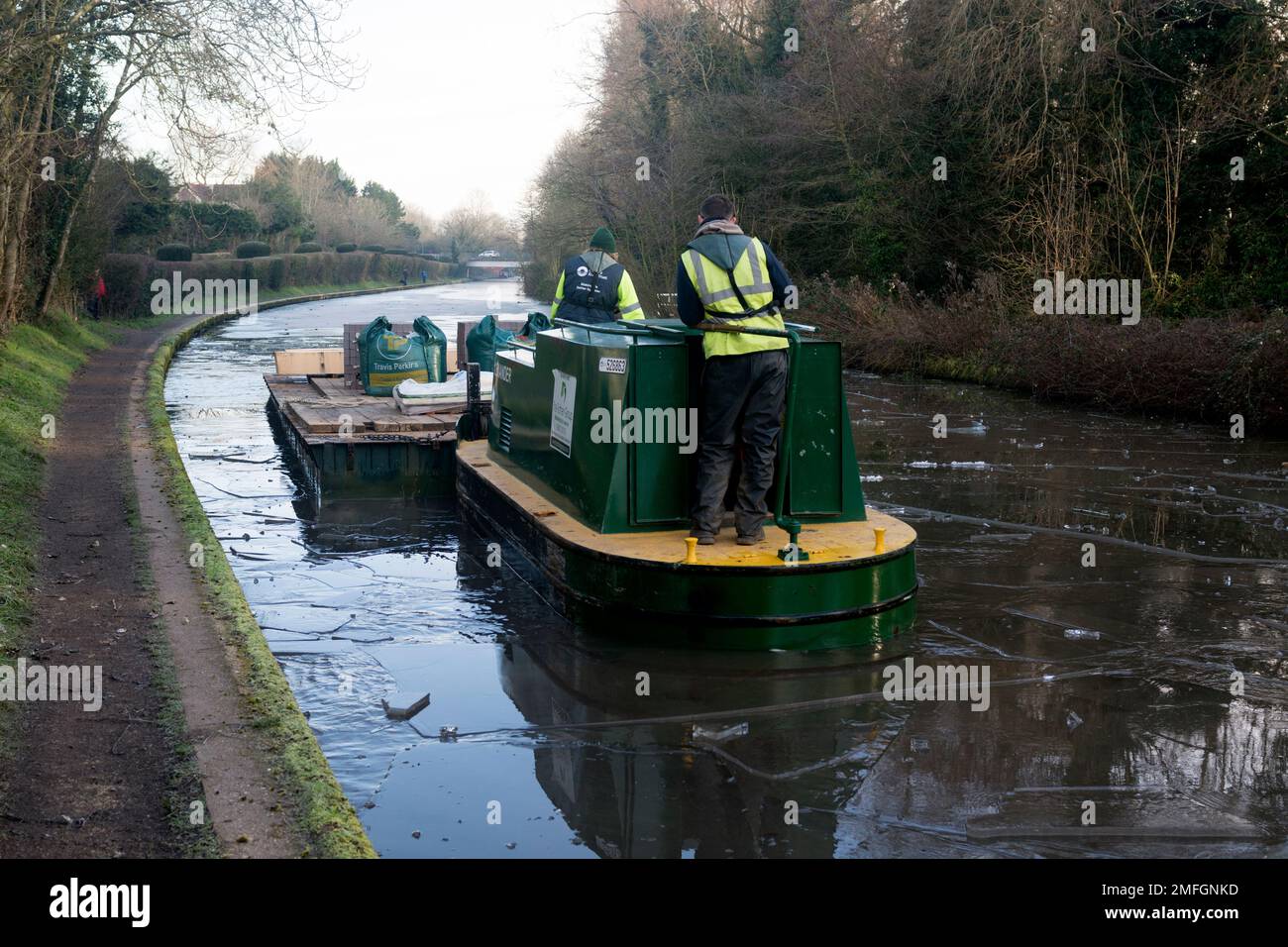 Ein Wartungsboot, das im Winter durch dickes Eis fährt, Grand Union Canal, Warwick, Großbritannien Stockfoto