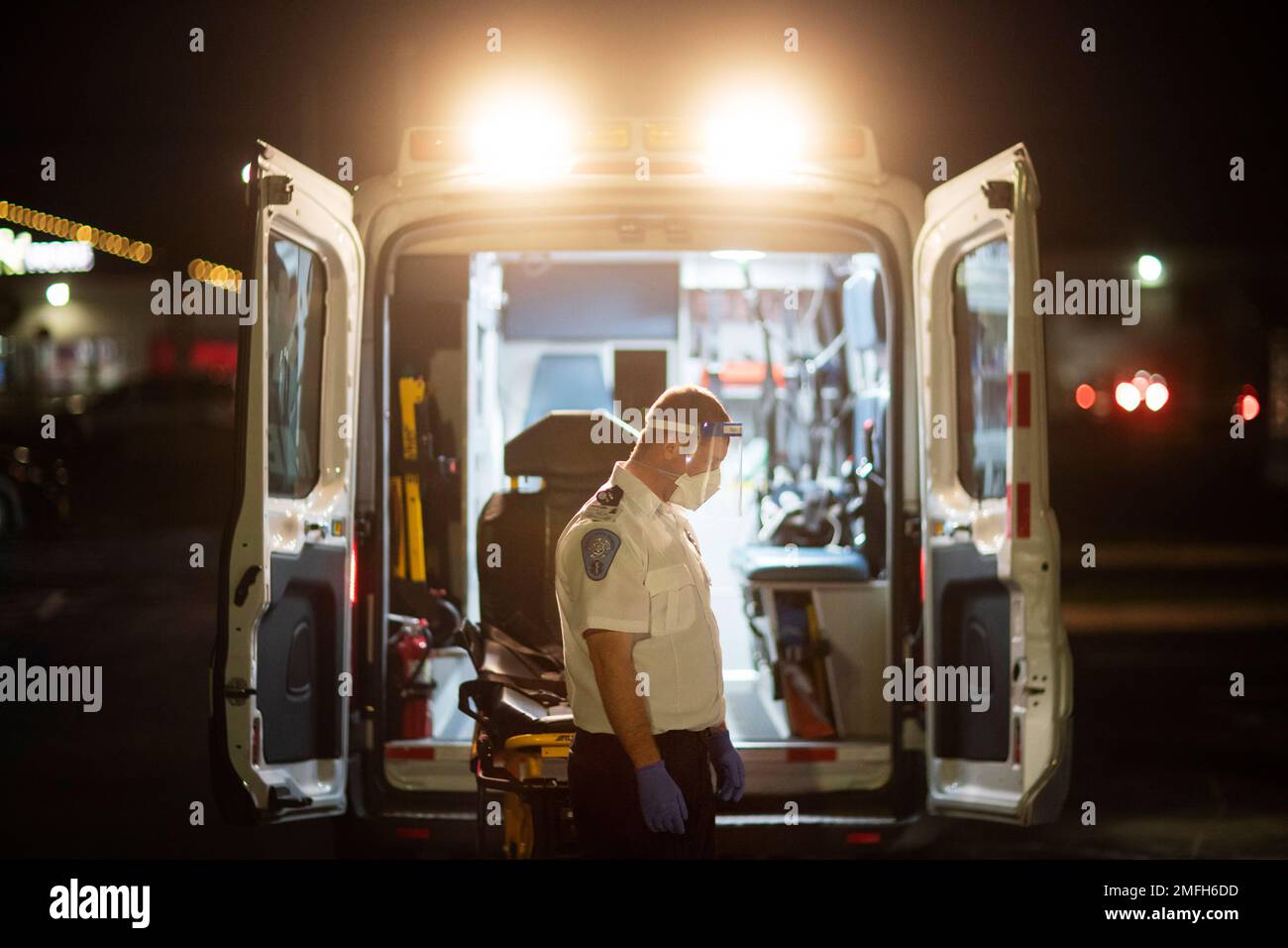 An EMT pauses for a moment while loading a stretcher back into an ambulance after dropping off a patient at a newly opened field hospital operated by Care New England for COVID-19 patients in Cranston, R.I, Tuesday, Dec. 1, 2020. (AP Photo/David Goldman) Stockfoto
