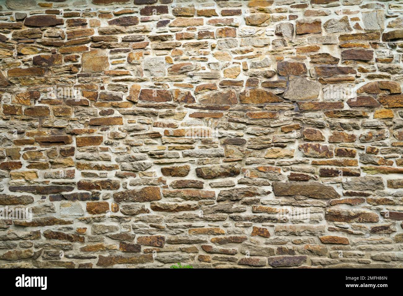 Alte Steinmauer eines Gebäudes. Steinwand als Hintergrund oder rustikales Muster für Tapeten. Stockfoto