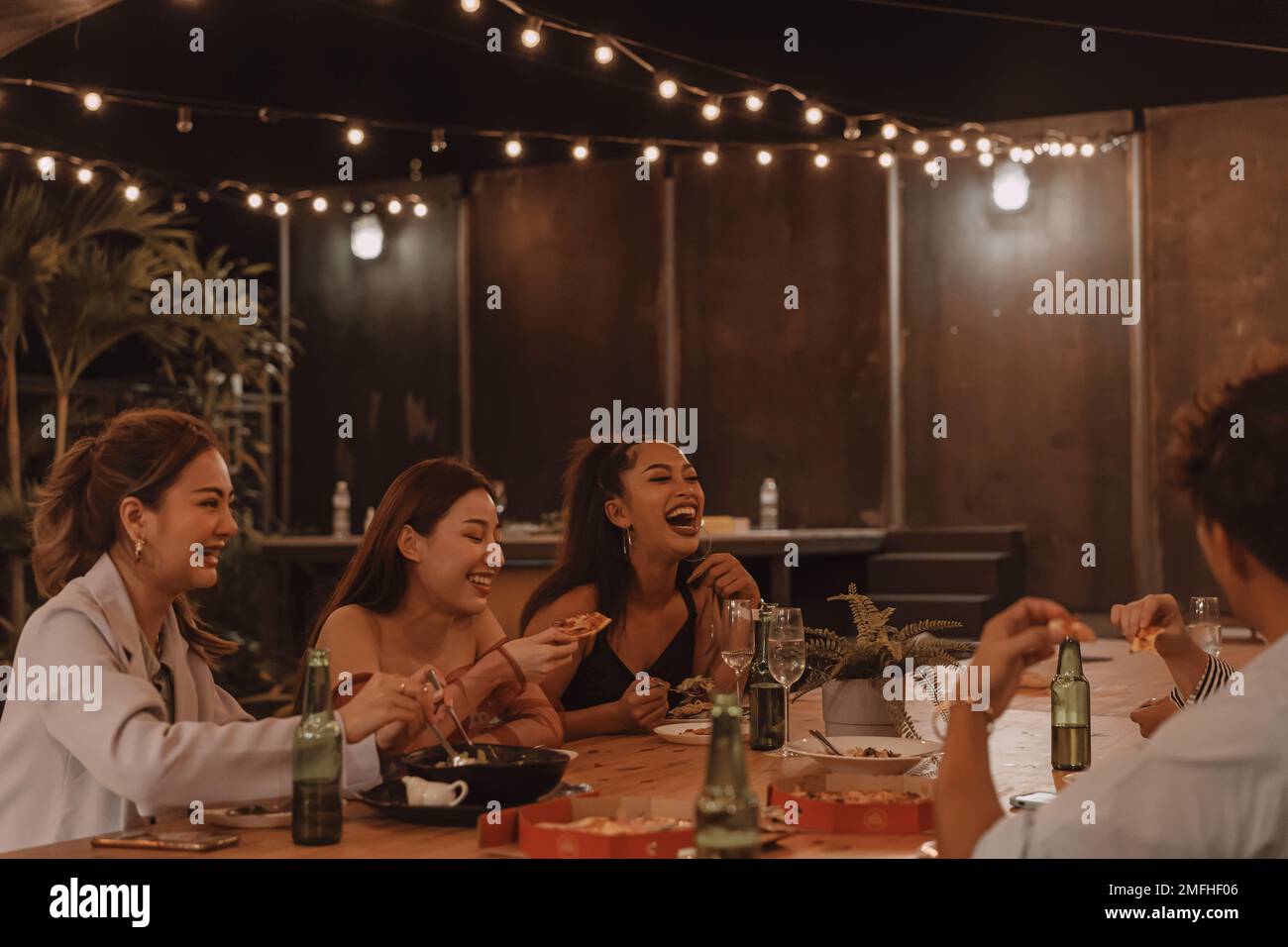 Junge asiatische Freunde essen und genießen gemeinsam das Abendessen im Restaurant im Freien. Freundschaft und Wiedersehensfeier Stockfoto