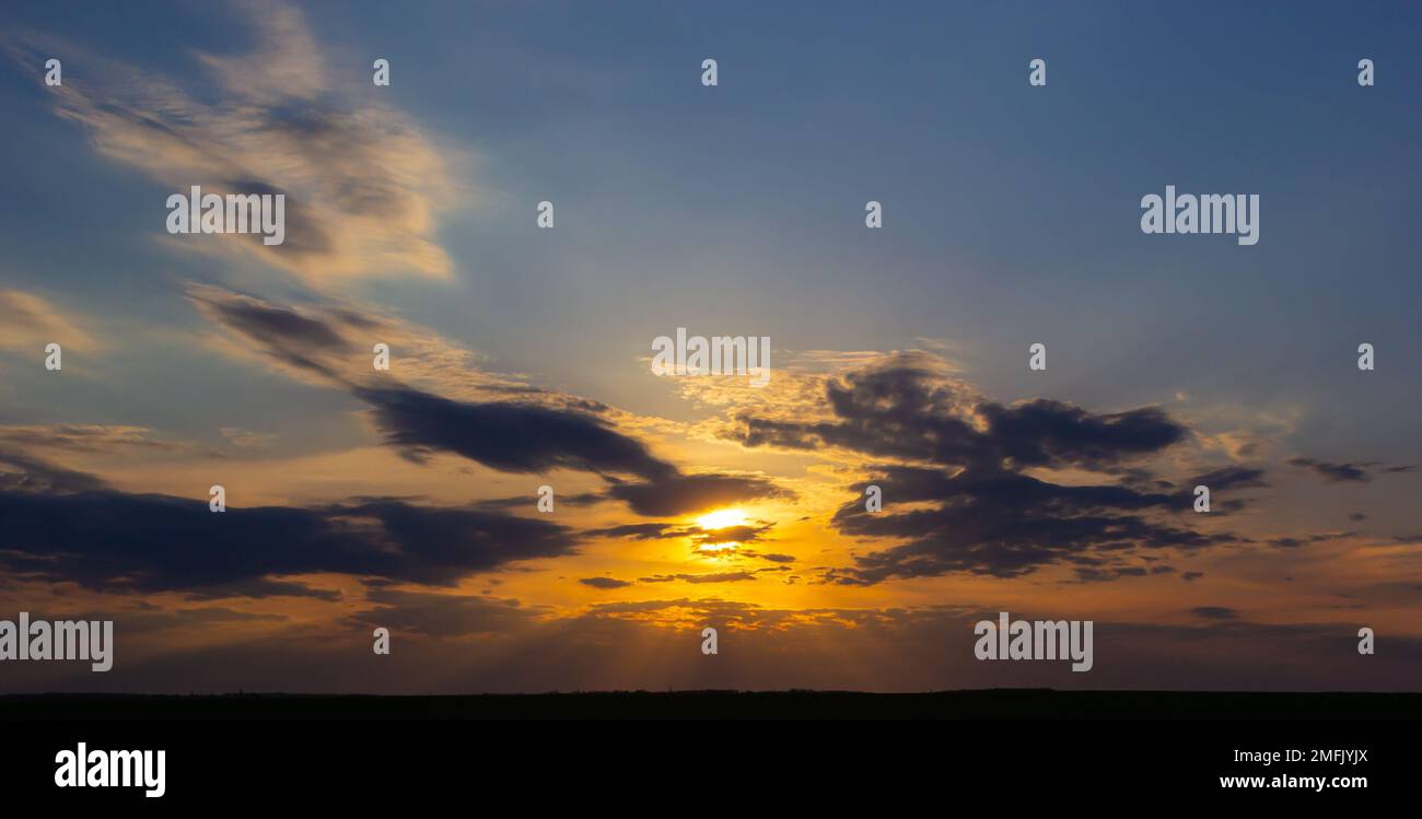 Sonnenuntergang am Himmel mit mehrfarbigen Wolken. Dramatischer Himmelshintergrund bei Dämmerung. Stockfoto