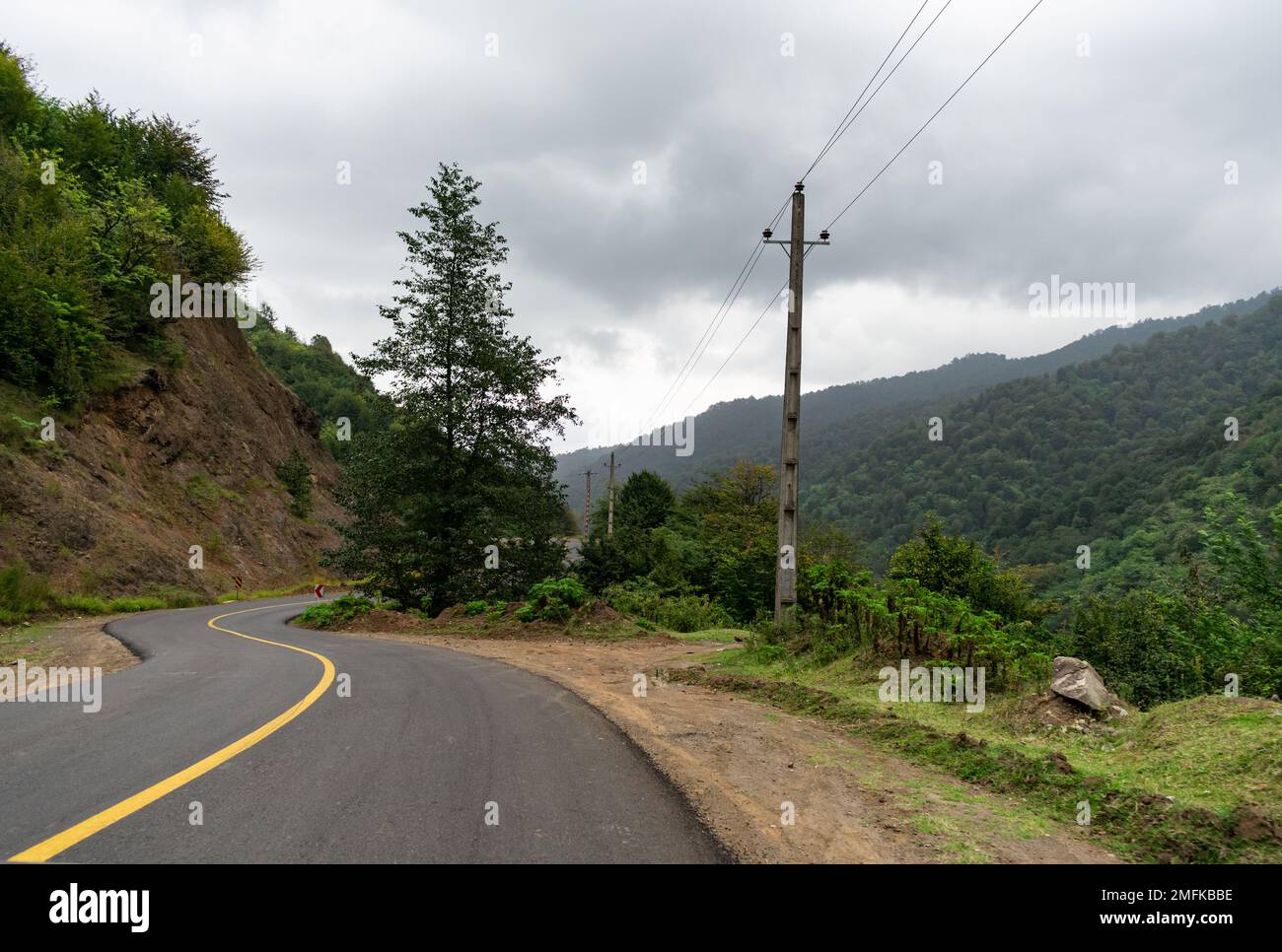 Bäume an der Seite der Bergstraße zwischen den Bergen voller... Stockfoto