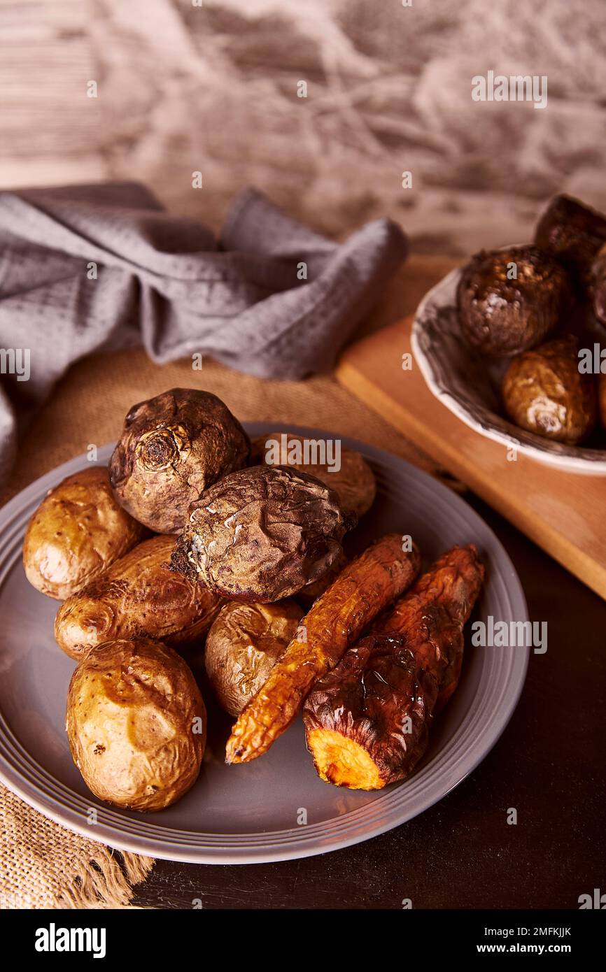 Gebackenes gegrilltes Gemüse - Karotten, Kartoffeln, rote Beete. Vollnahrung, mediterrane Ernährung. Vertikales Foto. Stockfoto