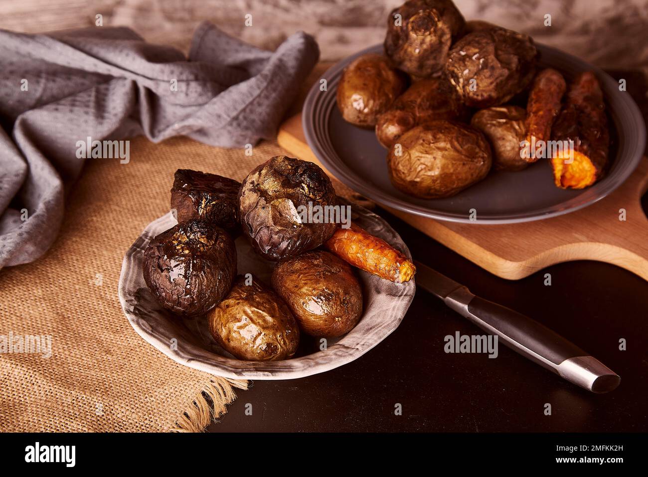 Gebackenes gesundes Gemüse auf rustikalem Hintergrund - Karotten, Kartoffeln, rote Beete. Vollnahrung, mediterrane Ernährung Stockfoto