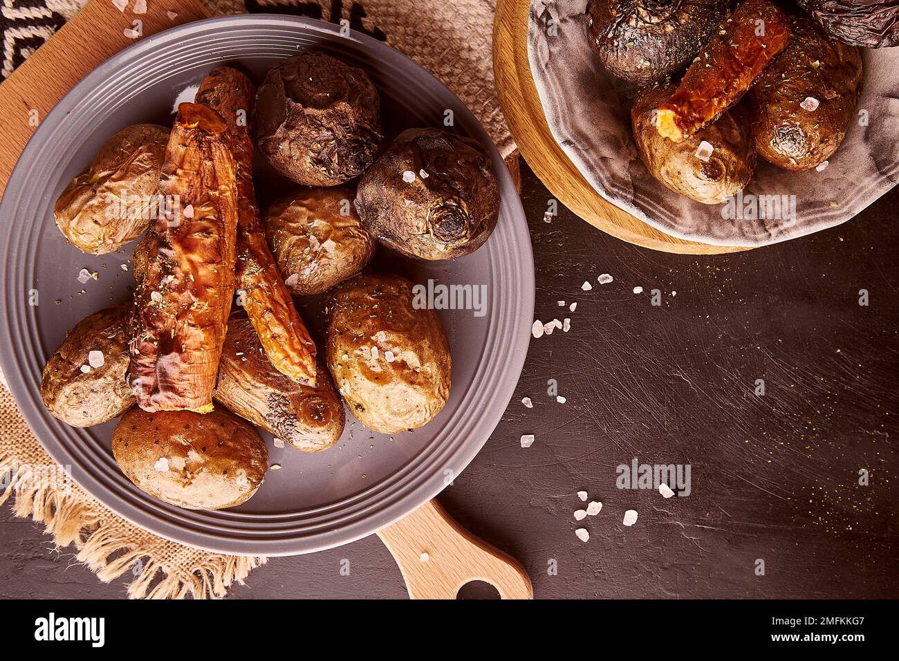 Gegrilltes, rustikales Gemüse - Kartoffeln, Karotten, Rote Bete. Gesundes Essen. Vollkost, DASH, mediterrane Diät auf natürlichem rustikalem Holzhintergrund Stockfoto