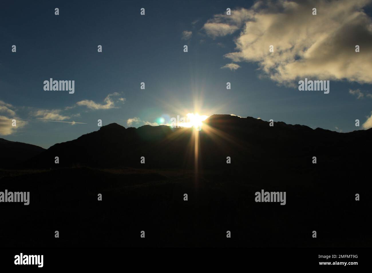 Sonnenaufgang über den silhouettierten Klippen mit blauem Himmel dahinter - Hintergrundkonzept für Neuaufgang, Hoffnung, Spiritualität, Neuanfänge Stockfoto