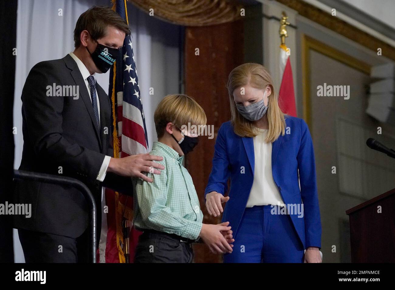 Missouri Auditor Nicole Galloway, right, takes the hand of her son