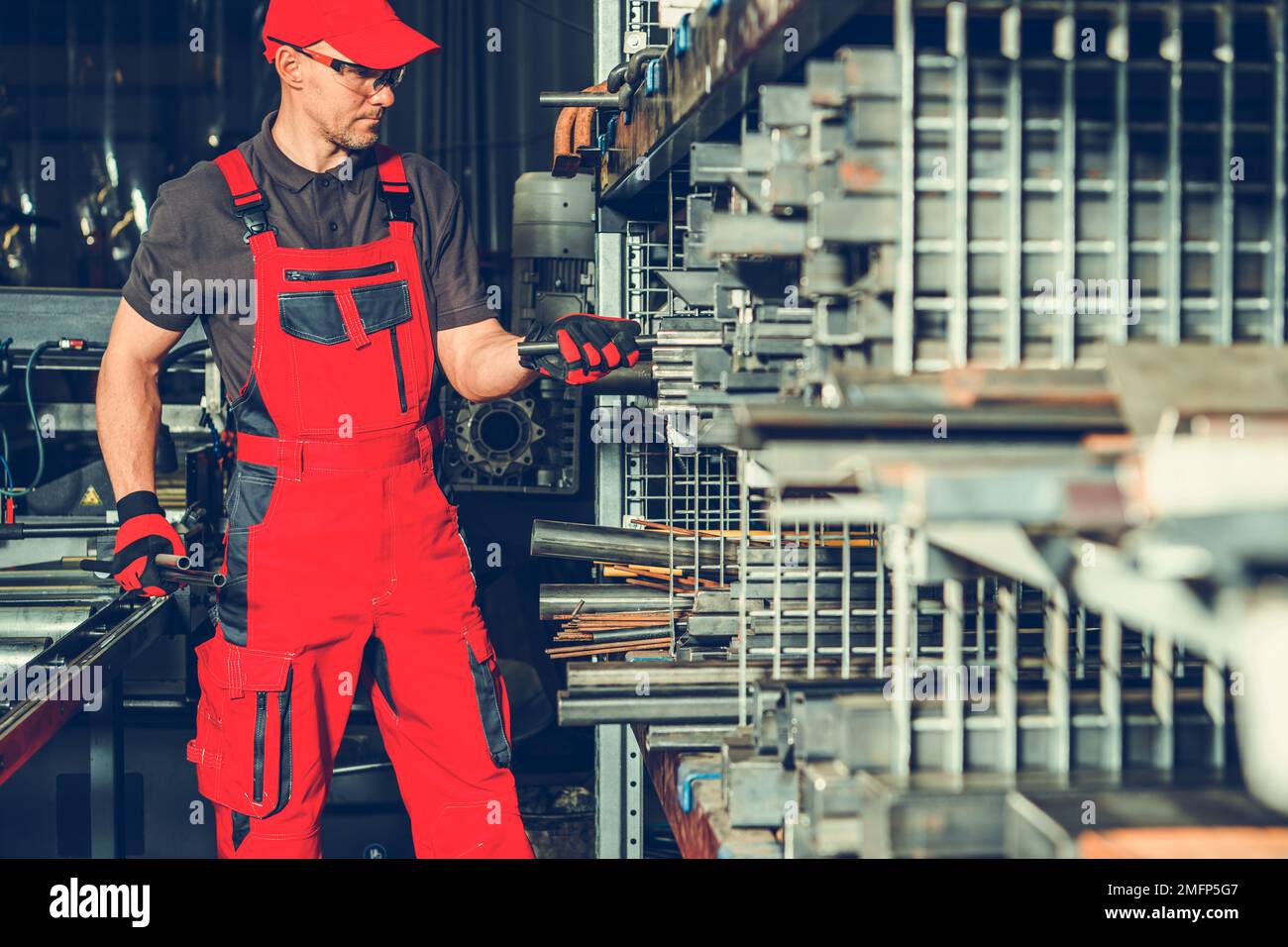 Mitarbeiter in der metallverarbeitenden Industrie auf der Suche nach dem richtigen Vierkantrohr für seine Arbeit. Stockfoto