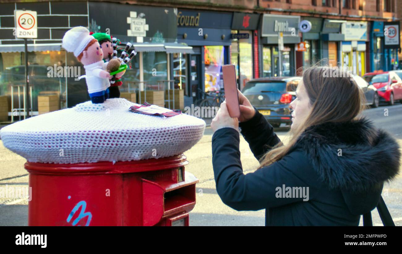 Glasgow, Schottland, Großbritannien 25. Januar 2023. Die Burns Night Strickpostszene auf der Dumbarton Road in partick erwies sich als ein Hit bei den Einheimischen, da der Pfeifer in den Haggis mit einem etikettierten Gedicht lief. Credit Gerard Ferry/Alamy Live News Stockfoto