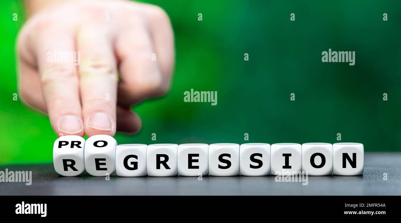 Die Hand würfelt und ändert das Wort Regression in Progression. Stockfoto