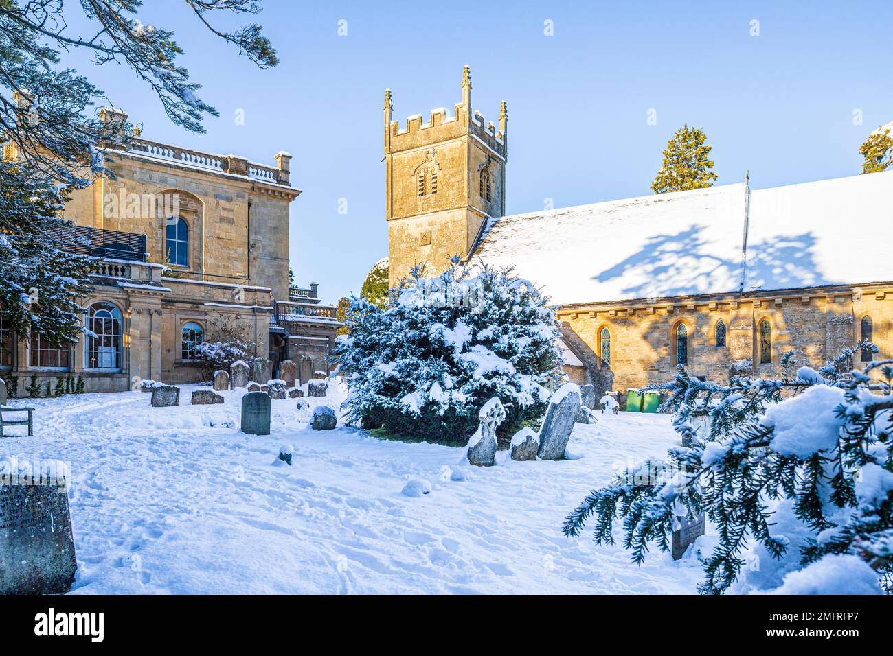 Frühwinterschnee auf der Kirche St. Mary neben dem Cowley Manor Hotel im Dorf Cotswold in Cowley, Gloucestershire, England Stockfoto