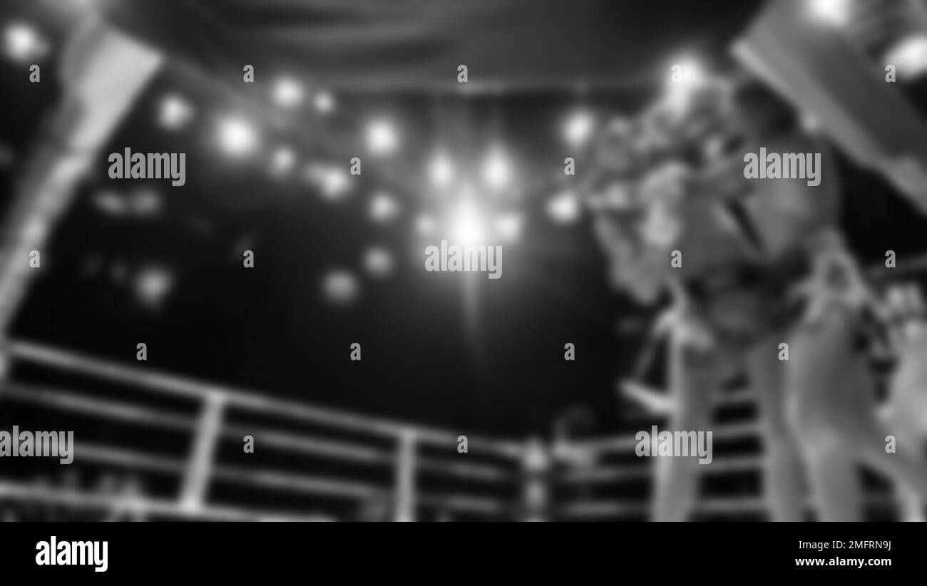 Verschwommene Bilder Schwarzweiß-Fotostil von Thai-Boxen oder Muay Thai oder Kickboxen, bei denen einheimische und foriegne Boxer im Innenbereich auf dem Ring kämpfen Stockfoto