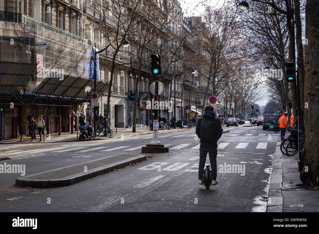 Ein Mann fährt mit einem Rad eine Pariser Straße hinunter. Stockfoto