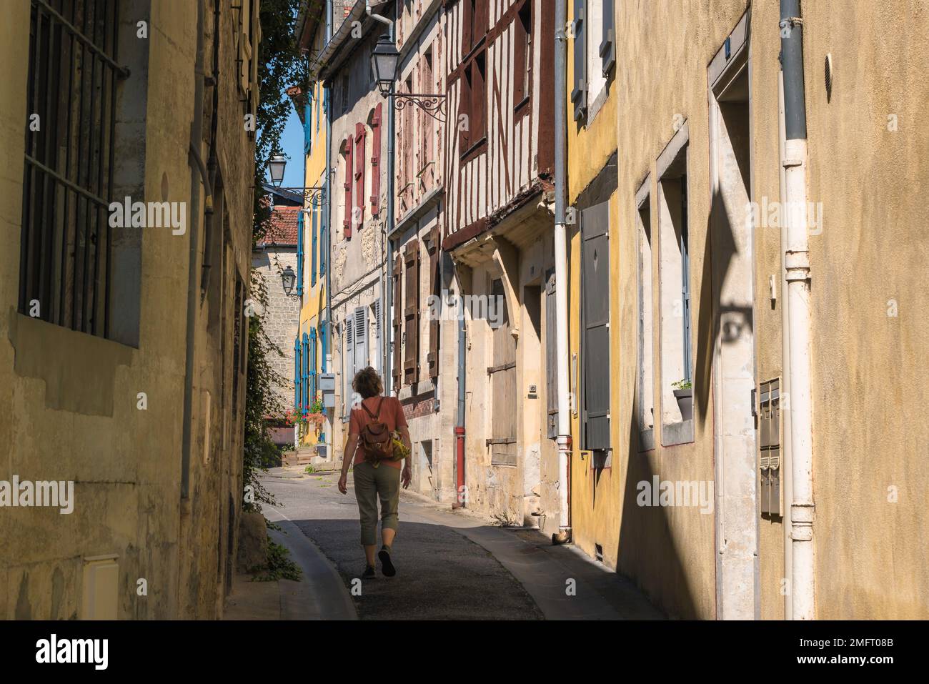 Traditionelles Frankreich, Rückansicht einer Reisenden mittleren Alters, die eine Straße in der malerischen Provinzstadt Joinville, Haute-Marne, Frankreich, erkunden Stockfoto