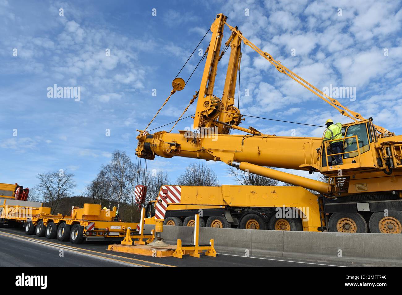 LKW-montierter Kran und Tieflader auf einer Baustelle in Deutschland Stockfoto