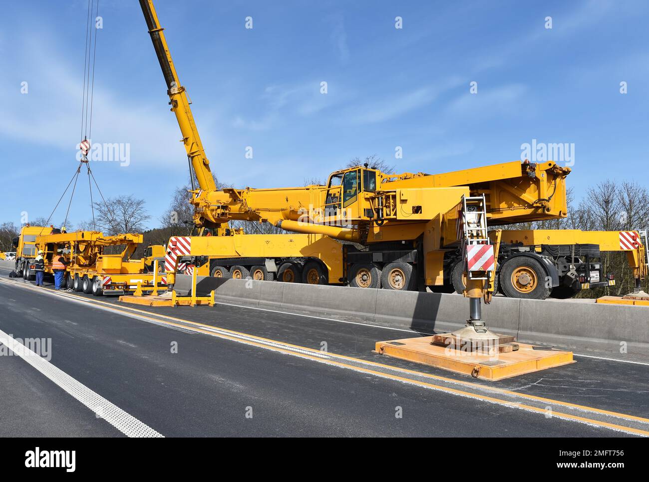 LKW-Kran Entladen eines Tiefladers, Deutschland Stockfoto