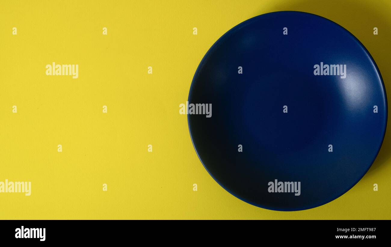 Leeres blaues Schild auf gelbem Hintergrund. Flach liegend mit Kopierbereich Stockfoto