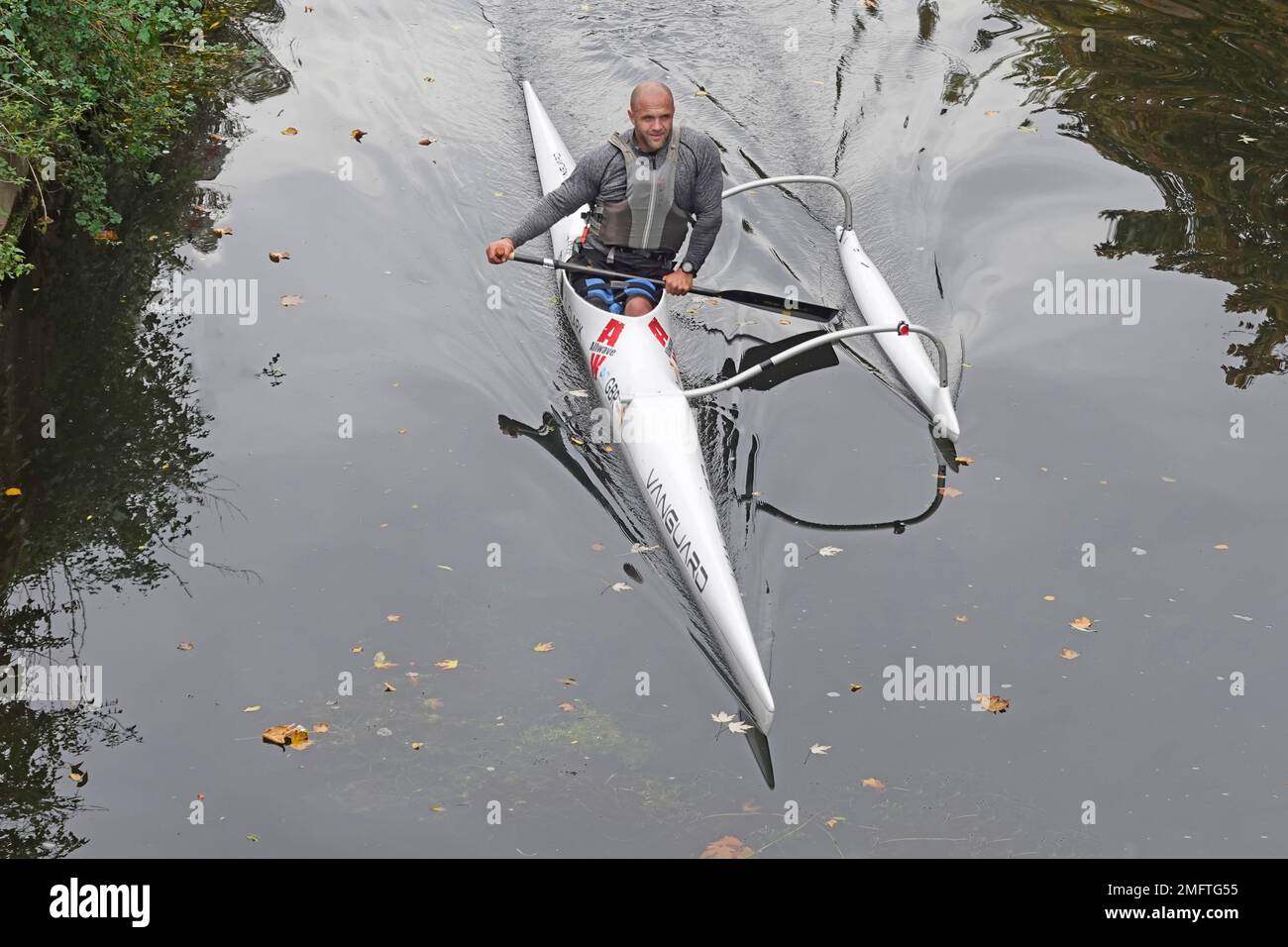 Kanufahren für Männer aus der Vogelperspektive im italienischen Allwave Vanguard Outrigger Kanu entlang der ruhigen Gewässer des River Can in der Stadt Chelmsford Essex England Stockfoto