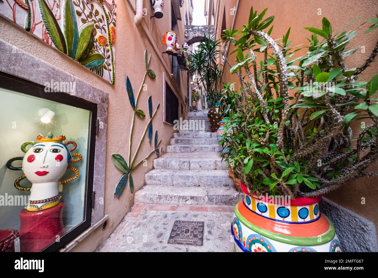 Kleine Gasse mit Treppen und kunstvoller Dekoration im alten Teil des Touristenziels Taormina. Stockfoto
