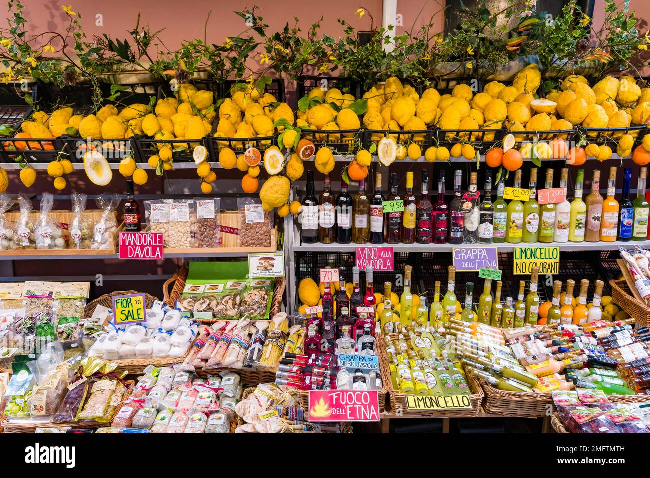Verschiedene Süßigkeiten, Likör und gelbe Zitronen werden im alten Teil des Touristenziels Taormina zum Verkauf angeboten. Stockfoto