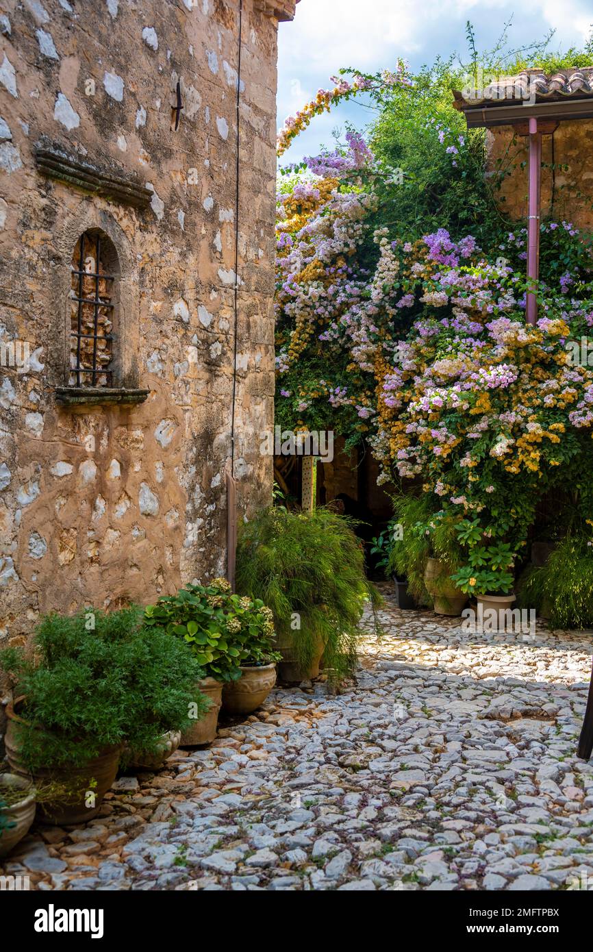Innenhof mit Blumen, Steingebäude, Moni Agnountos Kloster, Peloponnes, Griechenland Stockfoto
