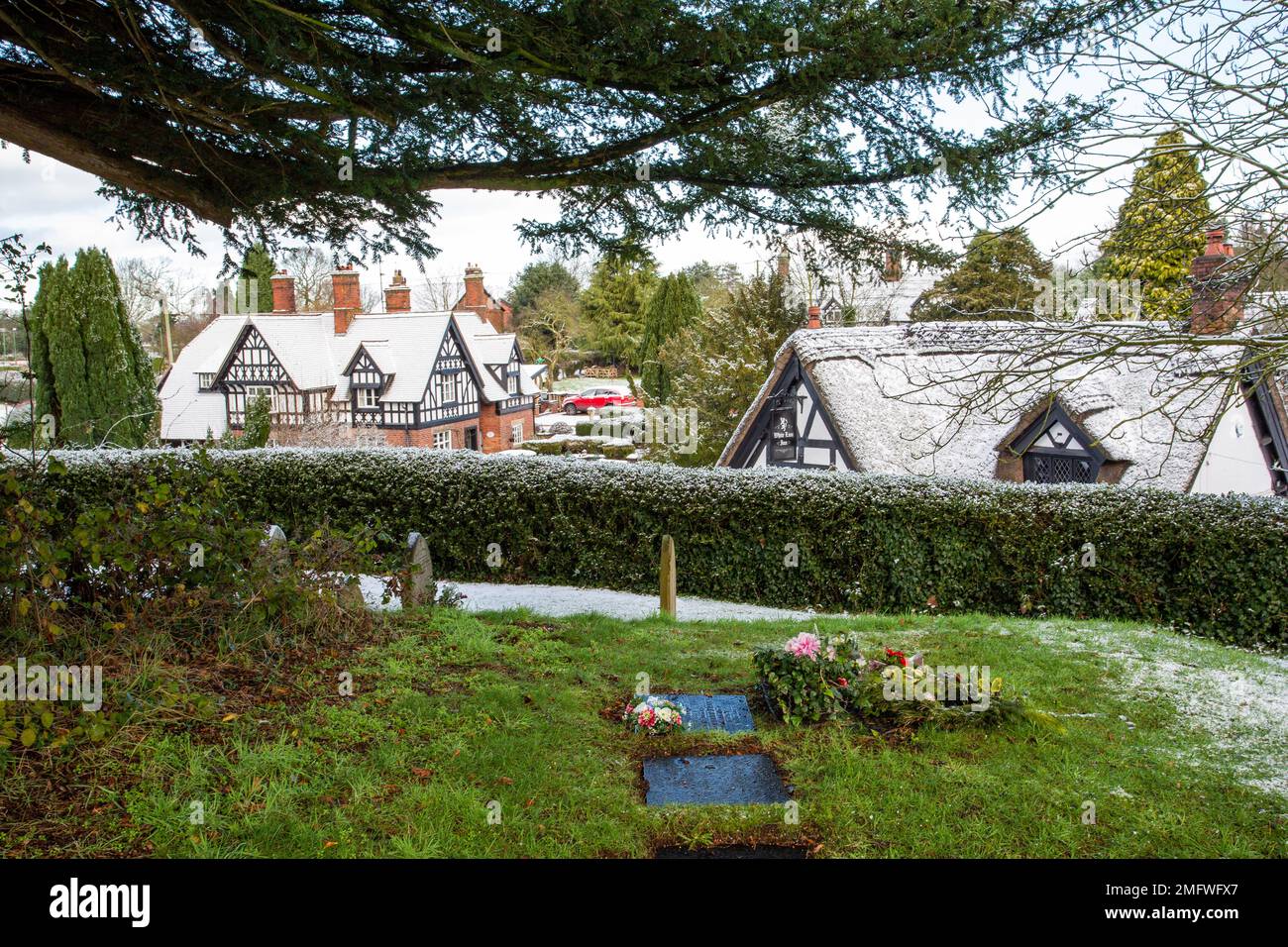 Schnee schwarz-weissen Fachwerkhäusern im malerischen Dorf Barthomley Cheshire England Großbritannien im Winter Stockfoto