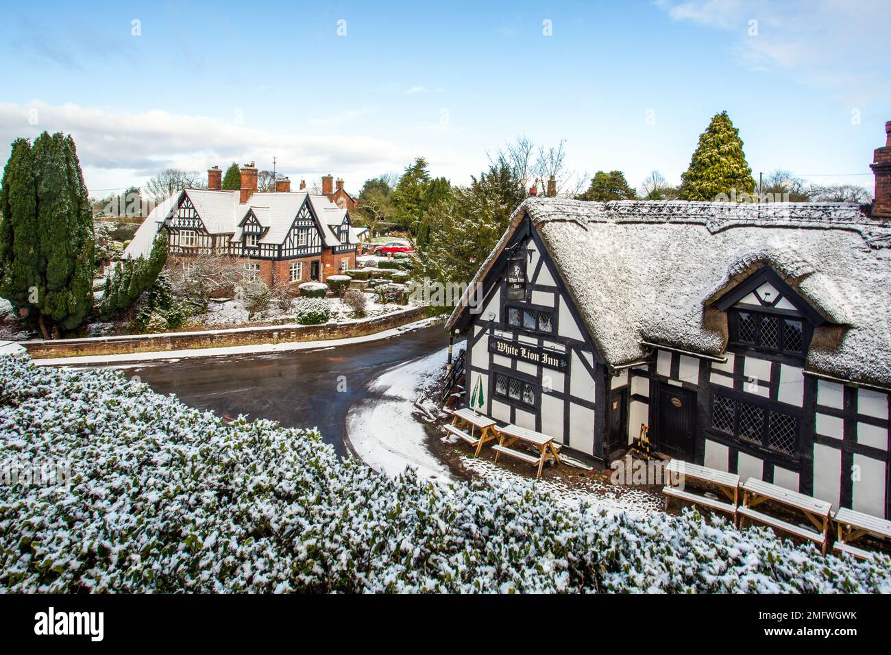 Schnee schwarz-weissen Fachwerkhäusern im malerischen Dorf Barthomley Cheshire England Großbritannien im Winter Stockfoto