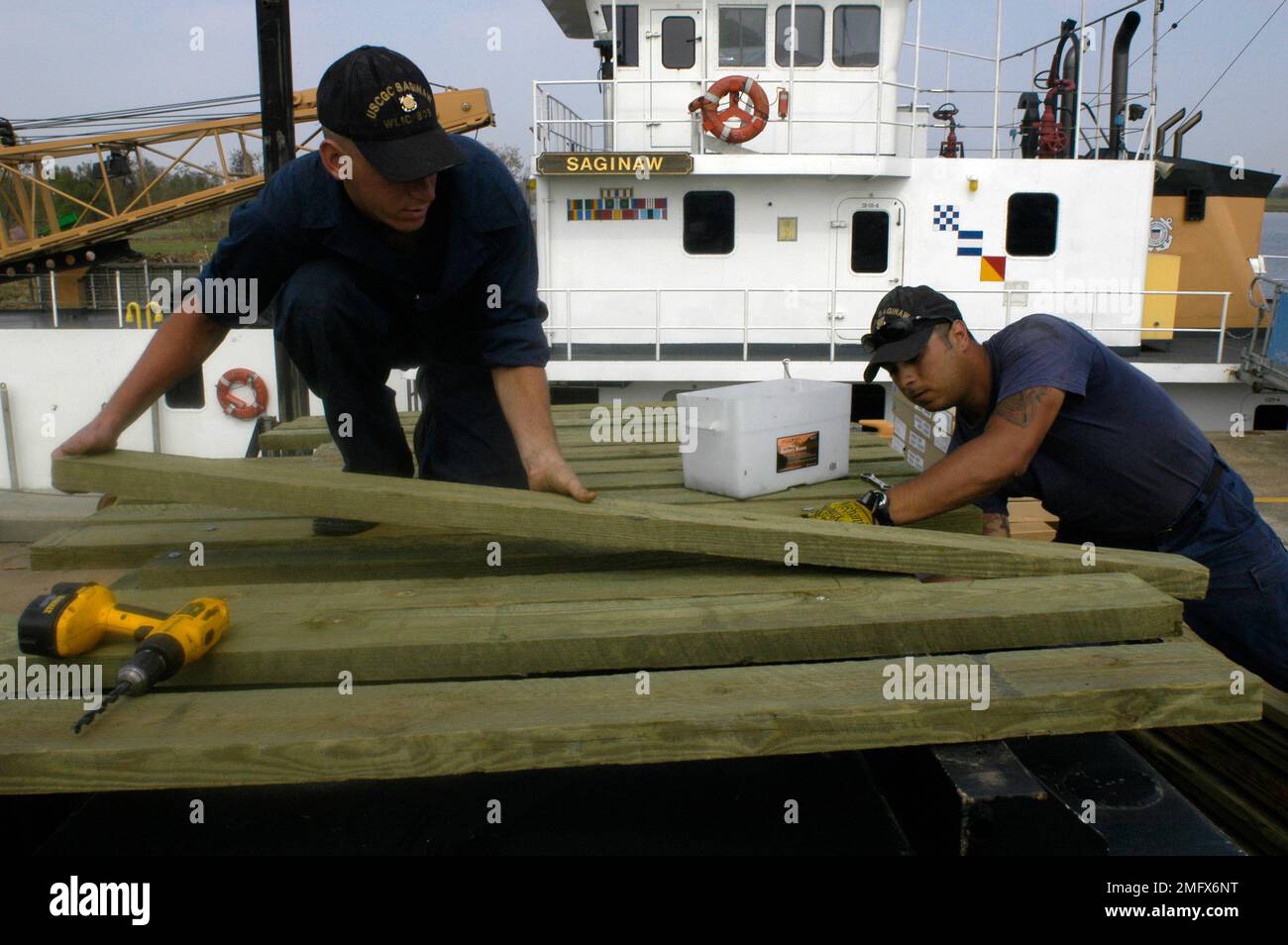Navigationshilfen - 26-HK-63-31. Küstenwachmänner arbeiten mit Holz in der Nähe von CGC Saginaw--ATON Ops. Hurrikan Katrina Stockfoto