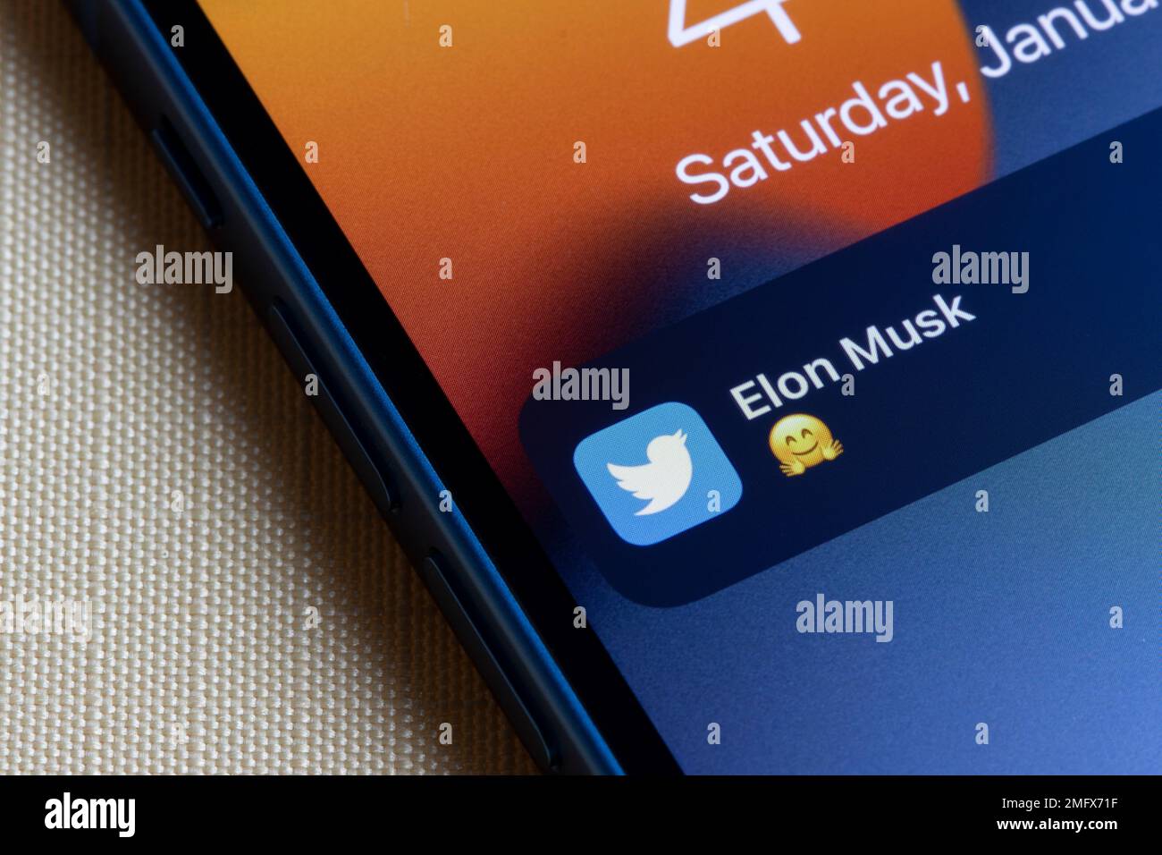 Eine Benachrichtigung über einen neuen Tweet von Elon Musk mit einem sich umarmenden Emoji-Gesicht wird auf dem Sperrbildschirm eines iPhone angezeigt. Elon Musks Twitterübernahmekonzept. Stockfoto