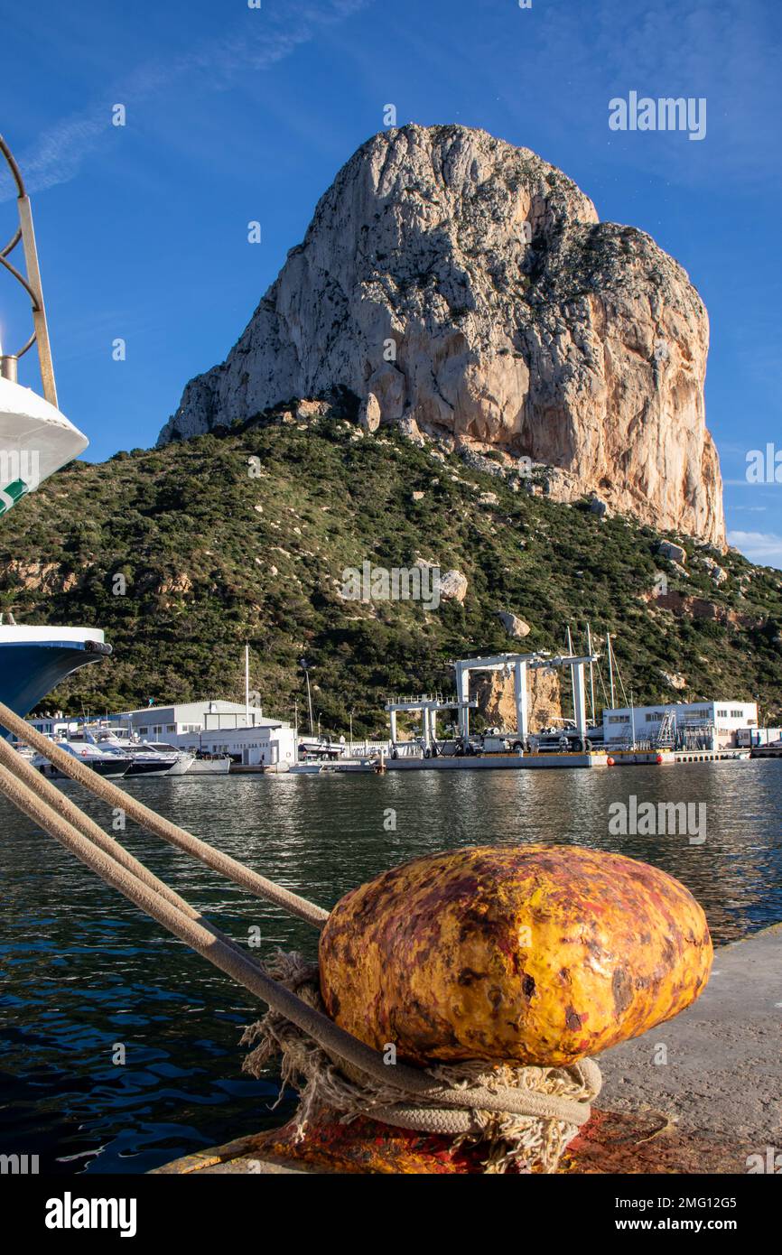 Amarre de un pesquero y al fondo el Peñón de Ifach. Todos los días sobre las cuatro de la tarde los barcos llegan al puerto desués de un largo día Stockfoto