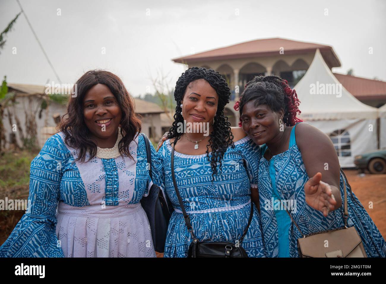 Drei reife afrikanische Frauen lächeln während einer Feier im Dorf zusammen Stockfoto