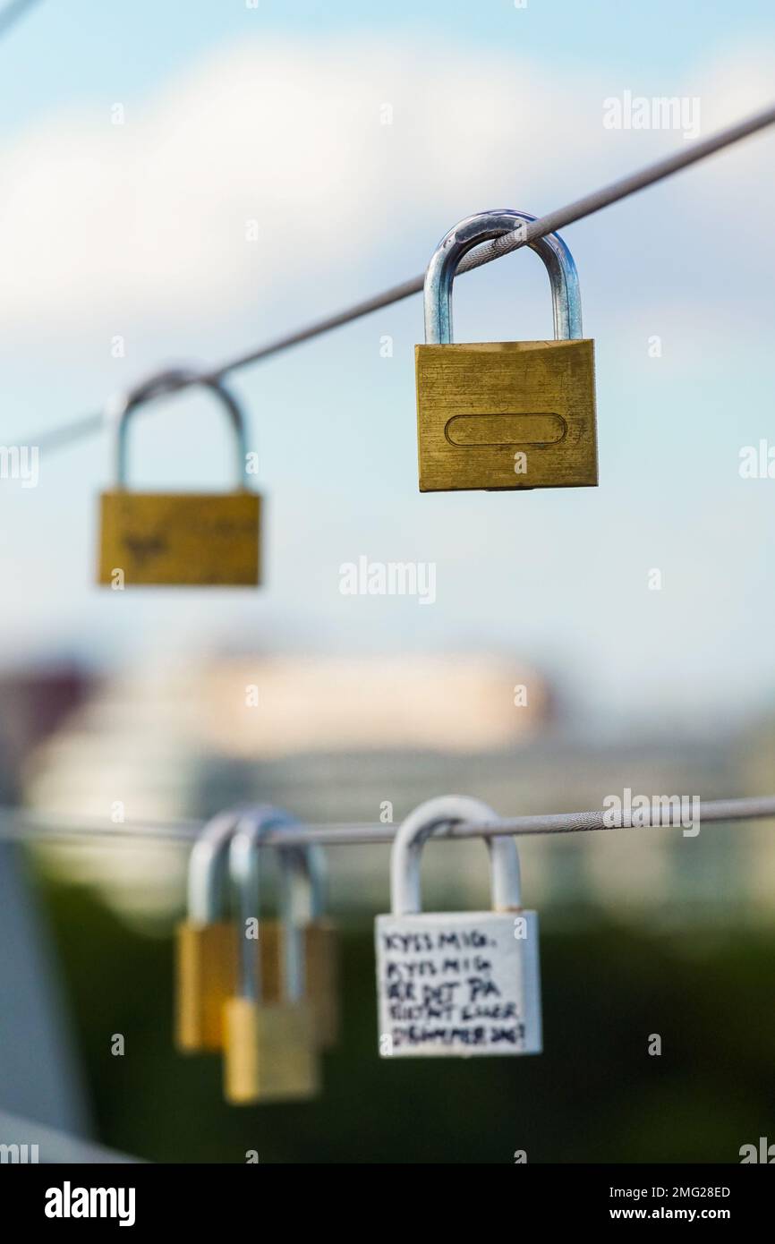 Nahaufnahme von Lovelocks, die an einem Metallzaun hängen Stockfoto