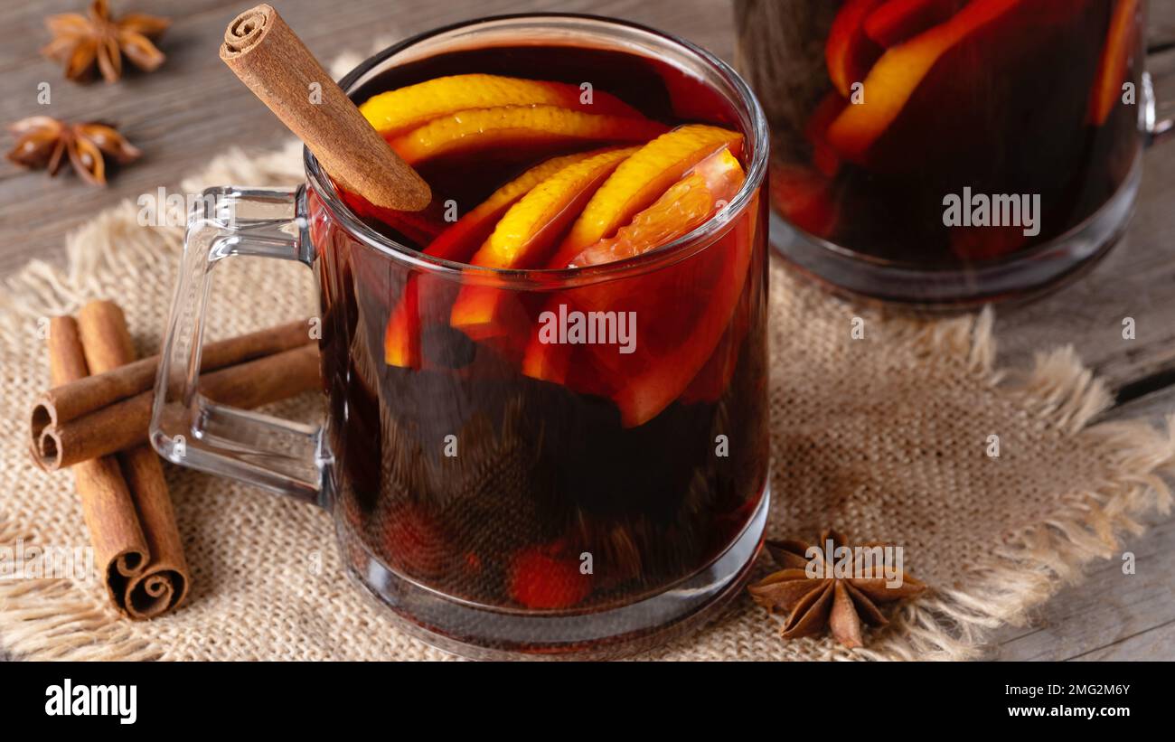 Glühwein in Glasbechern mit Gewürzen und Zitrusfrüchten Stockfoto