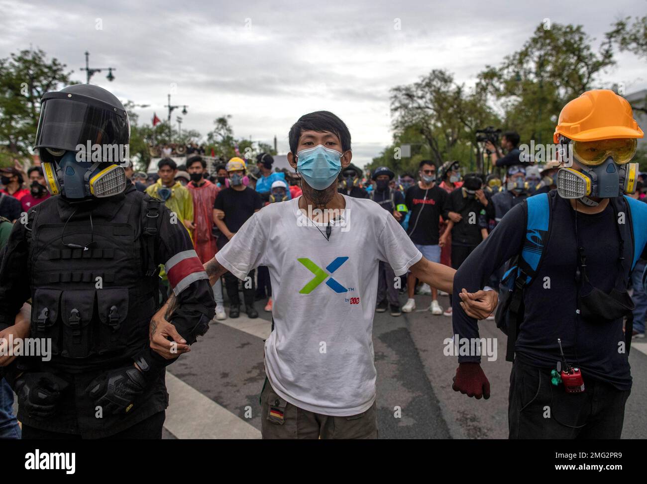 Pro-democracy protesters, some in protective tear-gas masks form a ...