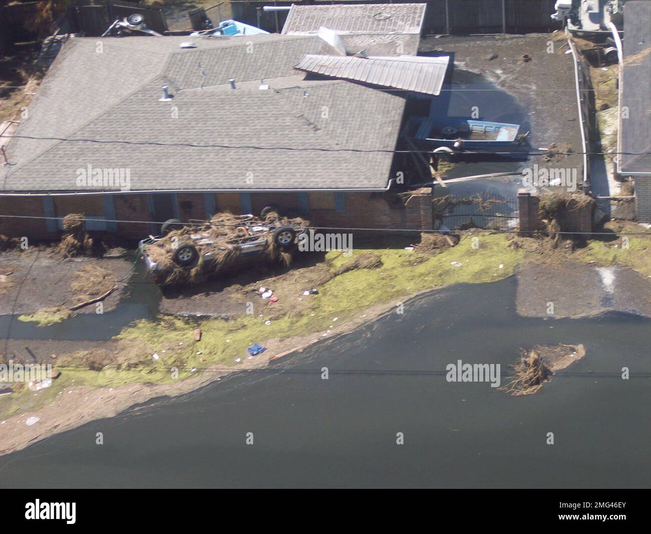 Nachwirkungen – Überflutung – Verschiedenes – 26-HK-36-128. Luftaufnahme eines umgestürzten Fahrzeugs und eines beschädigten Hauses im überfluteten Bereich. Hurrikan Katrina Stockfoto